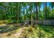 Landscaped backyard features a fire pit with Adirondack chairs and mature trees at 2016 Wild Flower Ln, Charleston, SC 29414