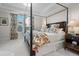 Bedroom with a four poster bed, and a view of the home exterior through the windows at 2020 Parish House Cir, Johns Island, SC 29455