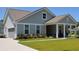 Well-maintained home features gray siding, a two-car garage, manicured landscaping, and a welcoming front porch at 2020 Parish House Cir, Johns Island, SC 29455