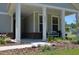 Inviting covered porch with white columns, brick accents, and a cozy bench with seating at 2020 Parish House Cir, Johns Island, SC 29455