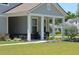 Charming home featuring a cozy covered porch with white columns, a bench, and manicured landscaping at 2020 Parish House Cir, Johns Island, SC 29455