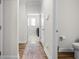 Hallway leading to the laundry room and a half bath, with wood flooring and a rug at 2020 Parish House Cir, Johns Island, SC 29455