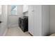 Well-lit laundry room with a new washer and dryer and ample cabinet space at 2020 Parish House Cir, Johns Island, SC 29455