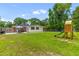 A spacious backyard features a playset, lush green grass, and mature trees, creating a peaceful outdoor retreat at 2045 Vestry Dr, Charleston, SC 29414