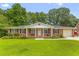 Charming single story brick home featuring a manicured front lawn and covered porch with swing at 2045 Vestry Dr, Charleston, SC 29414