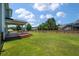 View of a large backyard with a covered deck and a wooden privacy fence at 214 Center Hill Ct, Summerville, SC 29485
