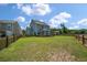 Wide shot of backyard with lush green grass, wooden fence, and raised deck at 214 Center Hill Ct, Summerville, SC 29485