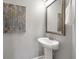 Stylish half-bathroom featuring a pedestal sink, decorative mirror, and modern artwork at 214 Center Hill Ct, Summerville, SC 29485