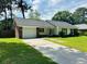 View of the home with a large driveway and front yard and attached garage at 214 Four Iron Dr, Summerville, SC 29483