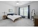 Bedroom with plush carpet, ceiling fan, and large window with blue patterned curtains at 220 Garden Gate Way, Summerville, SC 29486