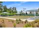 Community bocce ball court area, shaded seating, and landscaped greenery at 220 Garden Gate Way, Summerville, SC 29486