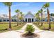 Exterior shot of community clubhouse lined with palm trees and American flags at 220 Garden Gate Way, Summerville, SC 29486
