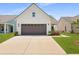 Charming home featuring a two-car garage, neutral siding, and meticulously manicured landscaping at 220 Garden Gate Way, Summerville, SC 29486