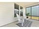 Screened patio with two Adirondack chairs, small table, patterned rug, and view of backyard at 220 Garden Gate Way, Summerville, SC 29486