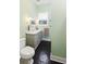 Bathroom with black and white floors, a modern vanity with a marble top, and a gray cabinet at 222 E Main St, Moncks Corner, SC 29461