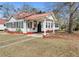 Exterior of a charming home featuring a red roof, covered side entrance, and lush yard at 222 E Main St, Moncks Corner, SC 29461