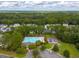 Aerial view of the community pool and playground surrounded by lush green trees and manicured landscaping at 230 Sweet Alyssum Dr, Ladson, SC 29456