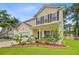 Charming two-story home with yellow siding, black shutters, well-manicured lawn and beautiful landscaping at 230 Sweet Alyssum Dr, Ladson, SC 29456