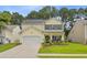 Charming two-story home with yellow siding, black shutters, well-manicured lawn and beautiful landscaping at 230 Sweet Alyssum Dr, Ladson, SC 29456