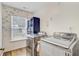 Bright laundry room with modern appliances, storage cabinet, and natural light from the window at 230 Sweet Alyssum Dr, Ladson, SC 29456