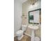 A charming half bathroom with patterned wallpaper, pedestal sink, and decorative mirror at 230 Sweet Alyssum Dr, Ladson, SC 29456
