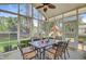 Screened sunroom with a dining table, overlooking the backyard with a trampoline and playset at 230 Sweet Alyssum Dr, Ladson, SC 29456