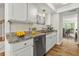 Well-lit kitchen features white cabinets, granite counters, stainless appliances and beautiful hardwood floors at 2333 Tall Sail Dr # G 607, Charleston, SC 29414