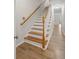 Hardwood staircase with white risers and railings leads to the upper level at 2333 Tall Sail Dr # G 607, Charleston, SC 29414