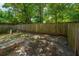 Landscaped backyard featuring brick patio and a tall wood fence at 235 Pine Shadow Dr, Goose Creek, SC 29445