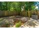 Fenced backyard featuring plants, small brick patio, and greenery at 235 Pine Shadow Dr, Goose Creek, SC 29445