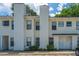 Inviting townhouse with light yellow siding, complemented by lush green bushes and ample parking at 235 Pine Shadow Dr, Goose Creek, SC 29445