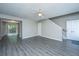 Spacious living room featuring modern gray floors, ceiling fan, and a welcoming front entrance at 235 Pine Shadow Dr, Goose Creek, SC 29445