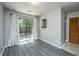 Living room with sliding glass door, gray laminate floors, and private backyard views at 235 Pine Shadow Dr, Goose Creek, SC 29445