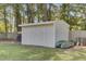 A cream colored storage shed sits on a large lot with mature trees and ample room for recreation and leisure at 25 Aldene Ave, Goose Creek, SC 29445
