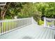 View of the outdoor wooden deck with blue railings and green trees in the background at 2613 Rivertowne Pkwy, Mount Pleasant, SC 29466