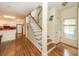Inviting entryway with hardwood floors leading to the kitchen and staircase with wooden handrail at 2613 Rivertowne Pkwy, Mount Pleasant, SC 29466