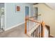 Upstairs hallway with white wood railing overlooking the foyer and open door to bathroom and laundry room at 2613 Rivertowne Pkwy, Mount Pleasant, SC 29466