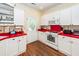 Charming kitchen with white cabinetry, red countertops, and a bright, airy feel at 2613 Rivertowne Pkwy, Mount Pleasant, SC 29466