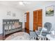 Bright Bedroom featuring a gray crib, cozy glider, and wood-look floors at 2650 Summer Leaves Ct, Charleston, SC 29414