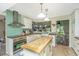 Bright kitchen featuring an island, farmhouse sink, stainless hood, and butcher block countertops at 2650 Summer Leaves Ct, Charleston, SC 29414
