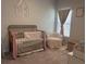 Bright Bedroom with a gold metal crib, cozy chair, and stylish monogram wall decor at 305 Camellia Bloom Dr, Moncks Corner, SC 29461