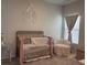 Cozy Bedroom featuring a metal crib, comfortable armchair, and soft pink decorative touches at 305 Camellia Bloom Dr, Moncks Corner, SC 29461