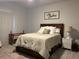 Cozy bedroom with a wooden bed frame, neutral color scheme, and carpet flooring at 305 Camellia Bloom Dr, Moncks Corner, SC 29461