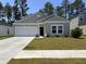 Charming single-story home with a well-manicured lawn and attached garage at 305 Camellia Bloom Dr, Moncks Corner, SC 29461