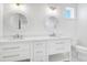 Bright bathroom featuring dual sinks, white cabinetry, and round mirrors at 305 Matilda St, Edisto Beach, SC 29438