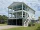 Beautiful three-story beach house with white siding and multiple covered decks for outdoor living at 305 Matilda St, Edisto Beach, SC 29438