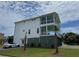 Two-story modern white home with a beautiful balcony view and well-manicured lawn at 305 Matilda St, Edisto Beach, SC 29438