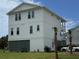 Modern three-story beach house with clean white siding and a well-manicured lawn at 305 Matilda St, Edisto Beach, SC 29438