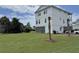 Expansive front yard with lush green grass, palm trees, and modern three-story home at 305 Matilda St, Edisto Beach, SC 29438