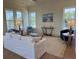 Bright living room with a plush sofa, decorative chairs, and three large windows at 305 Matilda St, Edisto Beach, SC 29438